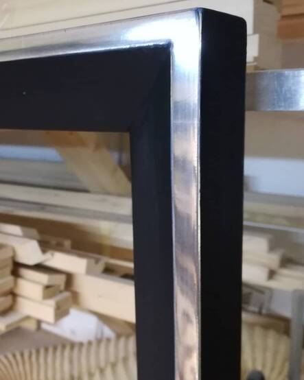 Fragment ramy – polerowane białe złoto 6K na niebieskiej glince kontrastujące z czernią w satynowym macie.