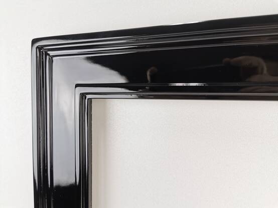 Zbliżenie narożnika czarnej ramy – lustro w ramie na wymiar z litego drewna