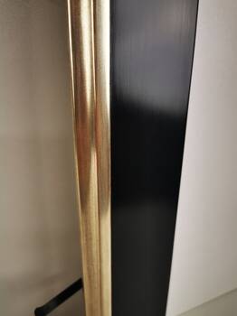 Białe złoto na czerwonej glince na brzegu ramy obrazu.