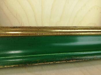 Makro ujęcie faktury ramy wykończonej politurą i woskiem, ze złotem 23 K