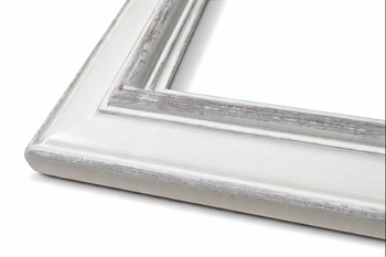 Naroże białej postarzanej ramy vintage – widok perspektywiczny od dołu, widoczna zaokrąglona zewnętrzna krawędź listwy i głębokość profilu z szarym postarzeniem na rzeźbionej części