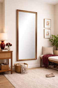 Lustro w czerwono-złotej ramie jako lustro stojące w nowoczesnym wnętrzu z drewnianą komodą
