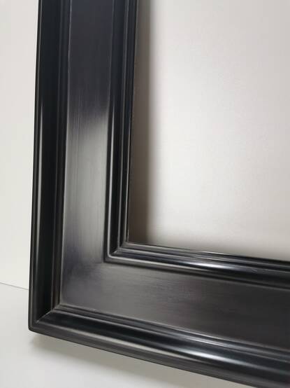 Zbliżenie narożnika lustra w szerokiej czarnej ramie satynowej o szerokości 120 mm – solidne łączenie na wpusty